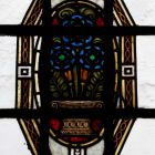 Épületfotó - a Kasselik-alapítvány üzlet-és bérháza (Budapest, Vörösmarty tér 3.) -virágvázás ornamentika a főlépcsőház második emeletének szélső üvegablakán