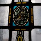 Épületfotó - a Kasselik-alapítvány üzlet-és bérháza (Budapest, Vörösmarty tér 3.) -madaras ornamentika a főlépcsőház második emeletének szélső üvegablakán