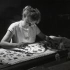 Fénykép - Borsi Sándorné textilrestaurátor egy úrihímzésű lepedőszél restaurálása közben az Iparművészeti
Múzeum textilrestaurátor műhelyében